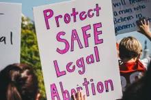 Protestschild mit der Aufschrift "Protect Safe Legal Abortion"