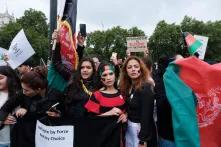 Drei Frauen mit Afghanistan Flaggen in der Hand und im Gesicht auf einem Protest in London. 